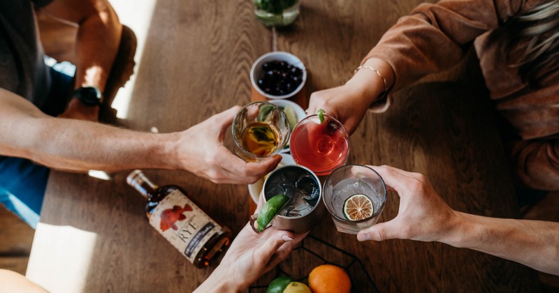 People clinking glasses together, top view