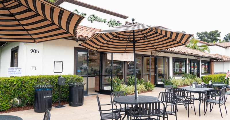 Exterior, a few sets of tables with chairs and sun umbrellas in front