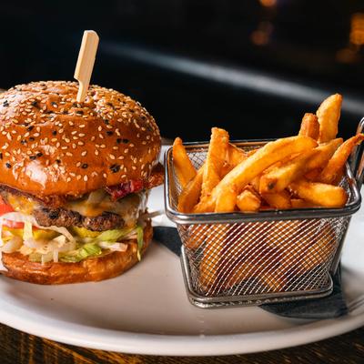 Bacon cheeseburger with a basket of fries.