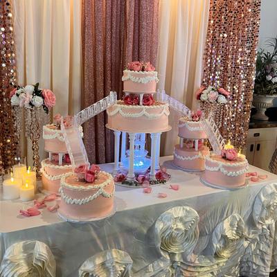 White wedding dessert table with a pink wedding cake and decorations