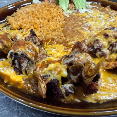Cheese-covered enchiladas served with rice and beans.