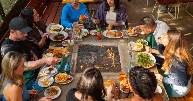 Interior, people dining at a fire pit table