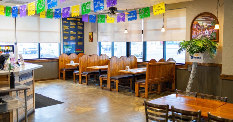 Interior, dining area, wooden seating booths with tables, large windows with blinds