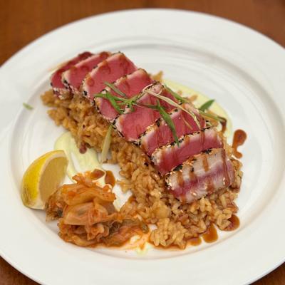 Sesame crusted tuna steak served on a bed of rice whit kimche on the side.