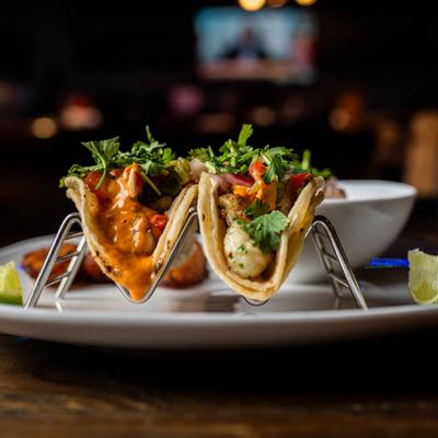 A shrimp taco and a fish taco on a plate.