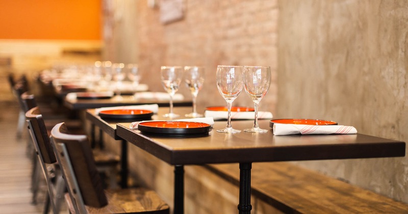 Interior, set tables, clean glasses and plates, cutlery, bare brick walls, lighting, decorations