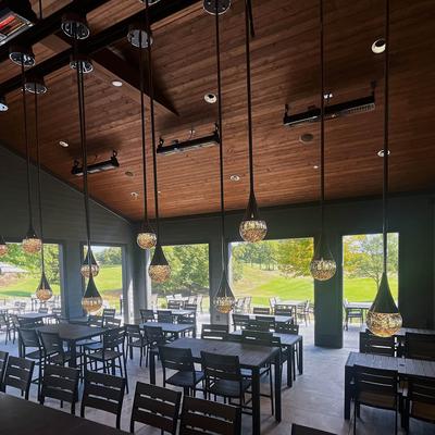 Patio cover, tables and seating with hanging lights and overhead heathers.