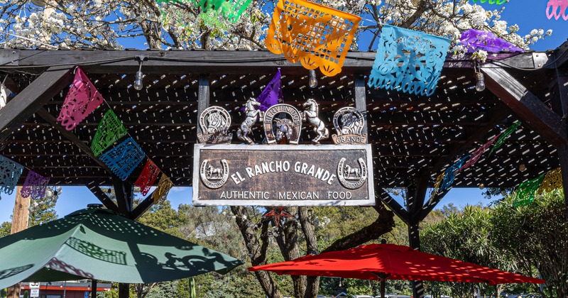Exterior, patio, hanging sign, board on wooden pergola, parasols