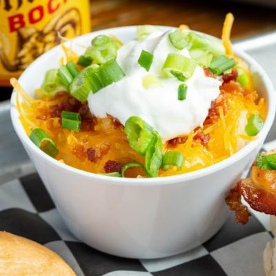 Loaded Mashed Potato Bowl topped with sour creme and green onion.