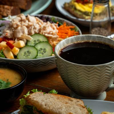 A soup bowl with other meals on the table.