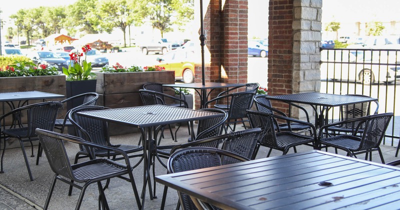 Patio, tables and chairs, flowers behind