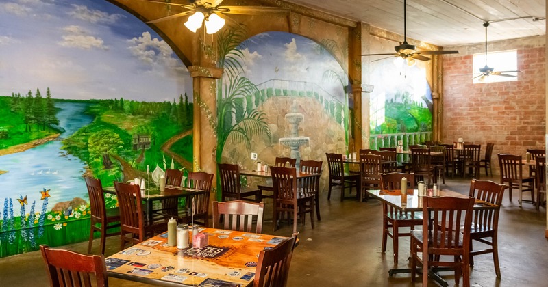 Interior, dining tables, large mural landscapes painted on the walls