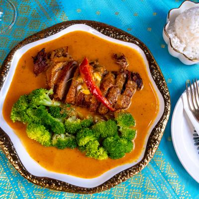Bangkok Duck in curry sauce, served with a side of broccoli and rice.