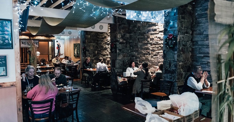 Guests enjoy food, booths made of stone walls