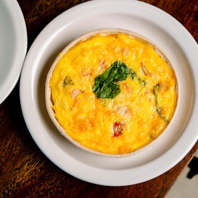 Quiche topped with a garnish of fresh greens, top view.