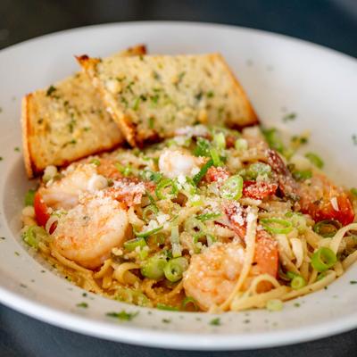 Sauteed shrimp, with tomato, scallions, lemon wine butter sauce, linguine, and garlic bread.