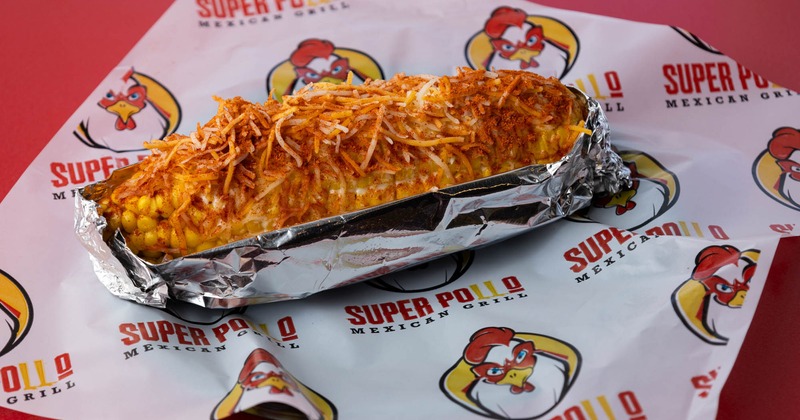 Corn on the cob topped with grated cheese and seasoning