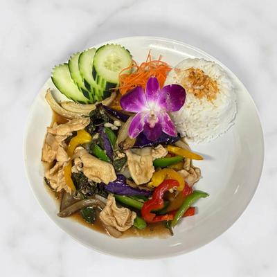 Thai stir-fried chicken with vegetables, rice, cucumber slices, and an orchid flower.