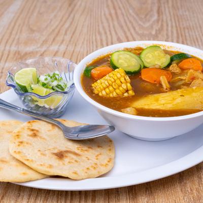 Tripe soup, with carrots, corn, cucumber, with salad and tortillas on the side