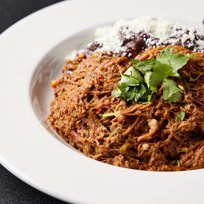 Stewed shredded beef served with black bean, cheese, fried plantains, and white rice.