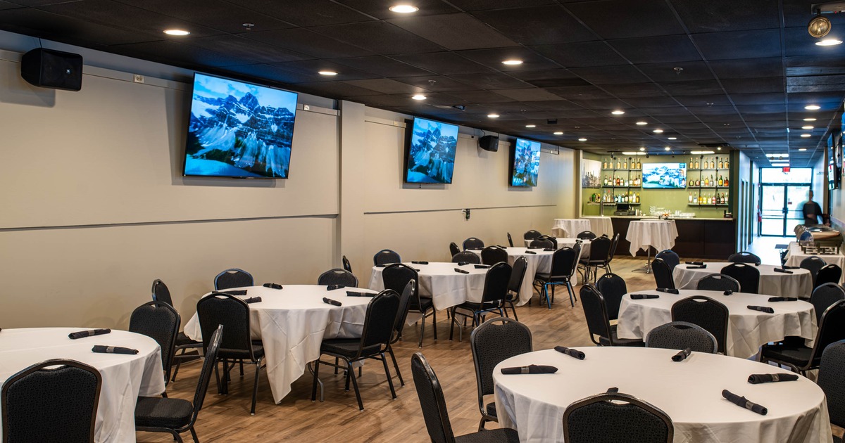 Interior - wooden tables, sports memorabilia on the walls, including framed jerseys and TVs