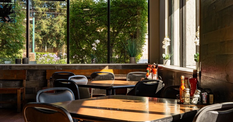 Interior, dining area, corner seating , tables with condiment trays, large windows