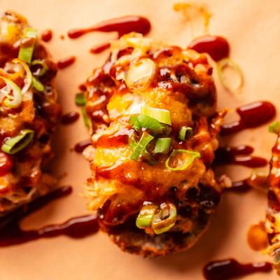 Potato Skins, topped with pulled pork, cheddar, scallions, house rub, and BBQ sauce.