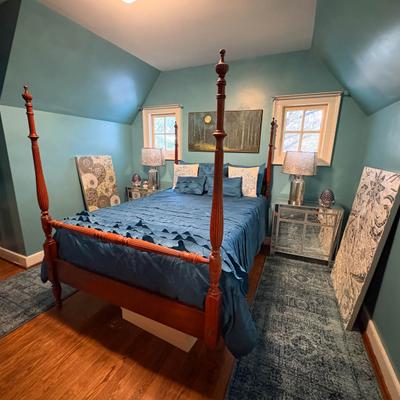Teal bedroom interior with blue bedding and mirrored nightstands.