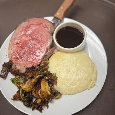 Prime rib with mashed potatoes, Brussels sprouts, and au jus.