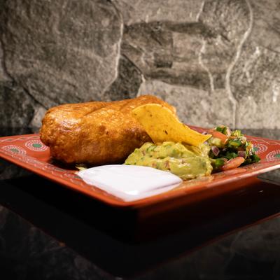 Chimichanga served with guacamole, sour cream, and salsa.