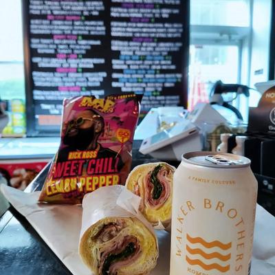 Bag of potato chips, a sandwich, and a can of drink.