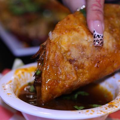 Birria taco dipped in broth.