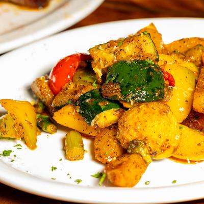 A plate of roasted vegetables seasoned with herbs.