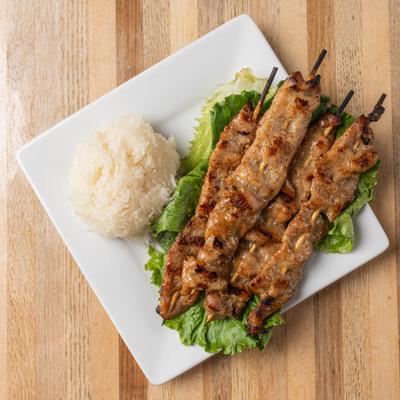 Tender Thai-style pork skewers served with sticky rice.