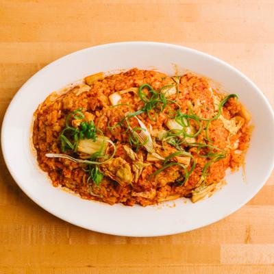 Fried rice topped with herbs on plate.