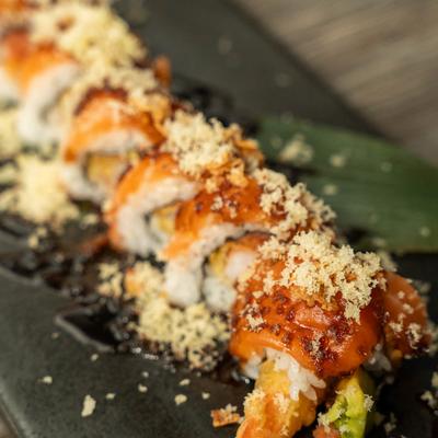 Shrimp tempura and tuna sushi rolls, topped with salmon, tempura flakes, and crispy onions.