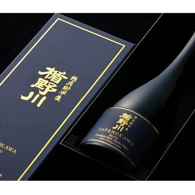 An elegant sake bottle with golden Japanese characters in a black box.
