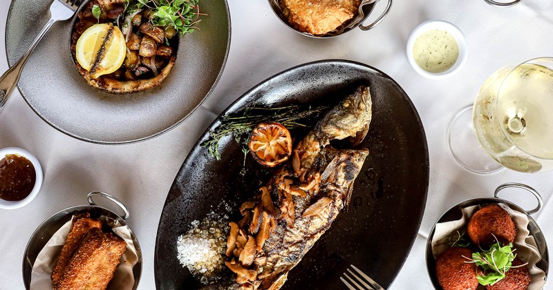 Branzino served with other food and wine