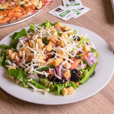 Garden salad with lettuce, mozzarella, croutons, tomatoes, olives, peppers, and onions.