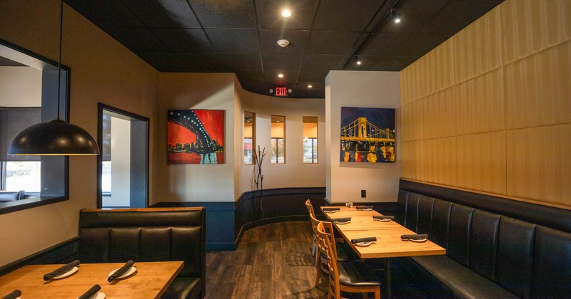 Interior, banquette seating with tables and dining booths, pictures on the walls