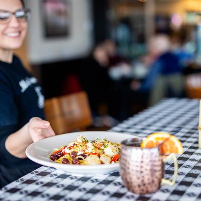 Shrimp and Scallops served on a dining table by an employee.