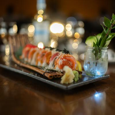 Specialty sushi roll on a tray with garnish.