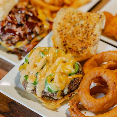 Rattlesnake burger topped with jalapenos and cheese, served with onion rings.