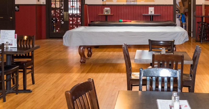 Interior, tables and chairs with pool tables in the back