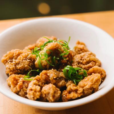 Crispy chicken bites garnished with green onions.