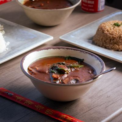 A bowl of spinach and mushroom curry.
