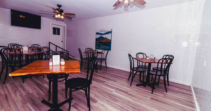 Interior, guest tables and chairs, a large wall TV