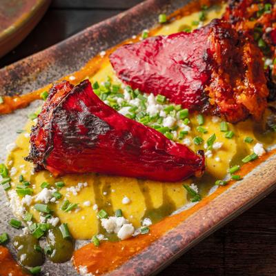Stuffed piquillo peppers topped with crumbled cheese.