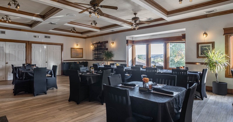 Interior dining area with black-clothed tables and chairs