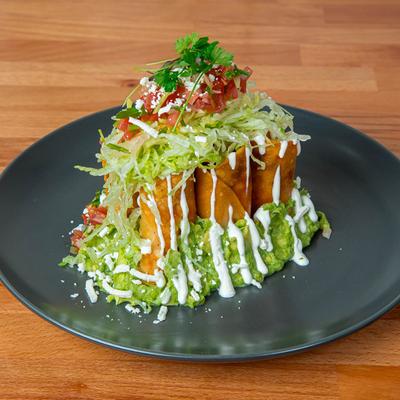 Taquitos with lettuce, salsa, guacamole, and sour cream.